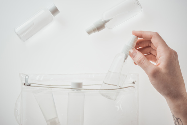vista recortada de la mujer sosteniendo botella con líquido sobre fondo blanco
  - Foto, Imagen