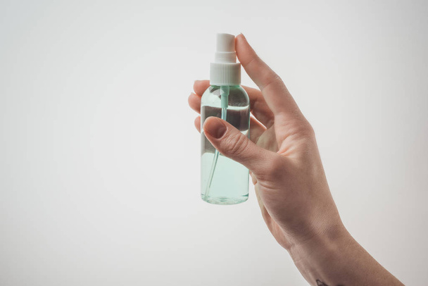 cropped view of woman holding bottle with liquid on white background  - Φωτογραφία, εικόνα
