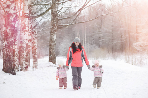 Los niños caminan en el parque en invierno. Bosque de invierno una familia con
 - Foto, imagen