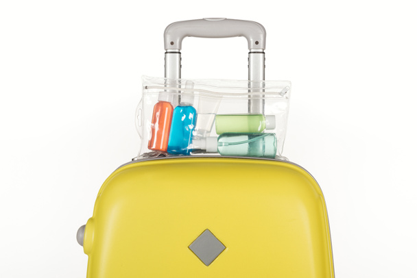 saco de viagem com saco cosmético com garrafas coloridas com líquidos isolados em branco
 - Foto, Imagem