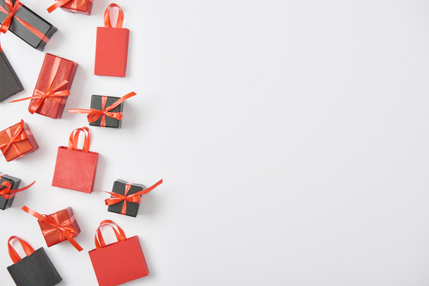 vista superior de regalos negros y rojos y bolsas de compras sobre fondo blanco
 - Foto, imagen
