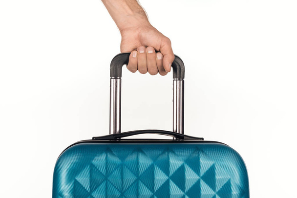 Beyaz arka planda renkli şişelerle dolu kozmetik çantalı seyahat çantası tutan adamın kırpılmış görüntüsü.  - Fotoğraf, Görsel
