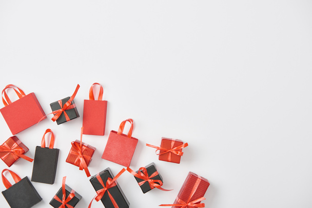 top view of black and red presents and shopping bags on white background with copy space - 写真・画像