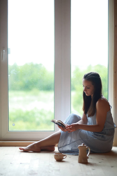 Ένα κορίτσι στο παράθυρο στο σπίτι - Φωτογραφία, εικόνα