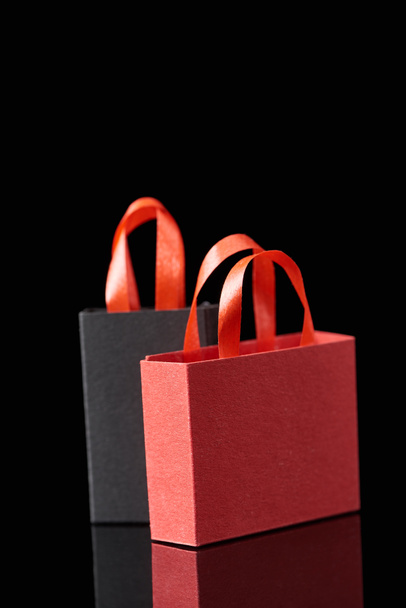 黒で隔離された赤いハンドルの紙のショッピングバッグ - 写真・画像