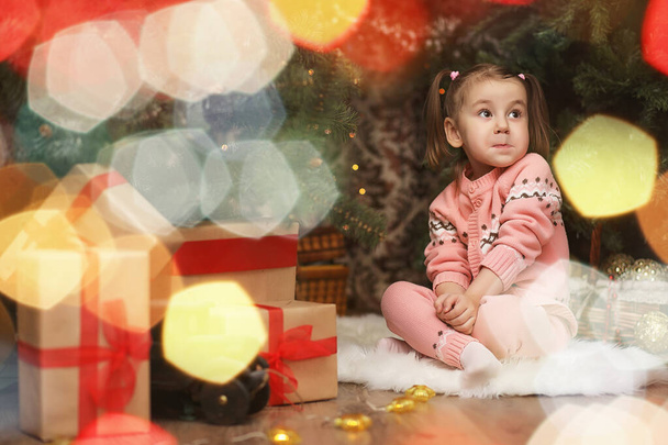 kleines Mädchen in weihnachtlicher Atmosphäre. Das Mädchen ist happ - Foto, Bild