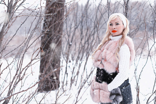Blondes Mädchen bei einem Spaziergang in einem Winterpark - Foto, Bild