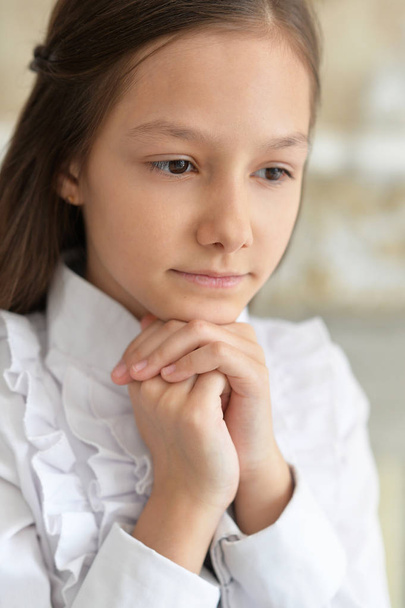 Sad little girl in white blouse posing at home  - Valokuva, kuva