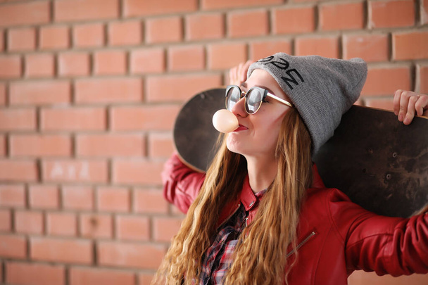 Una giovane hipster sta cavalcando uno skateboard. Ragazze amiche f
 - Foto, immagini
