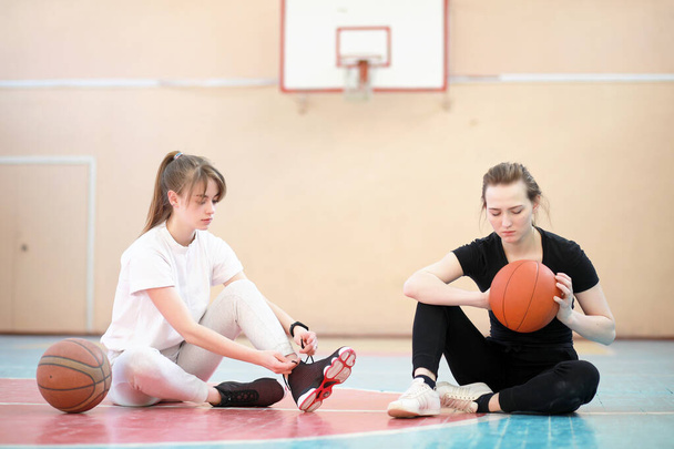 Menina no ginásio jogando uma bola de basquete
 - Foto, Imagem