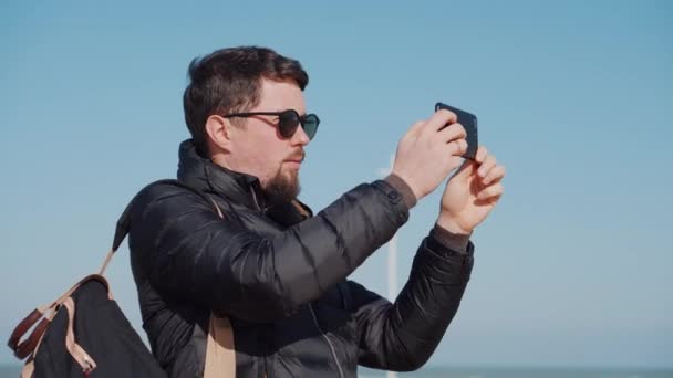 tourist in sungasses films attractions on smartphone - Кадри, відео