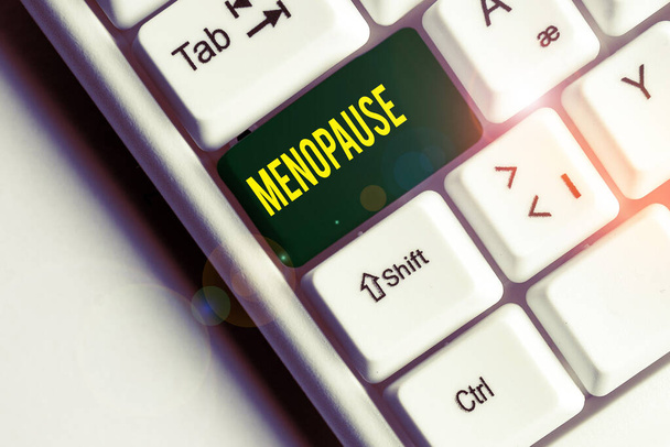 Handwriting text writing Menopause. Concept meaning Period of peranalysisent cessation or end of menstruation cycle White pc keyboard with empty note paper above white background key copy space. - Photo, Image