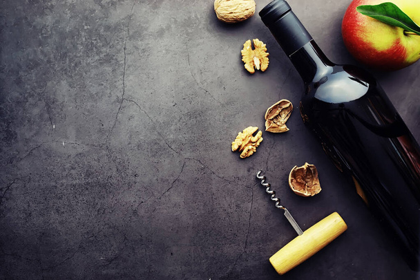 Бокал вина и бутылка черного вина. Орехи сыр и помидоры для S
 - Фото, изображение