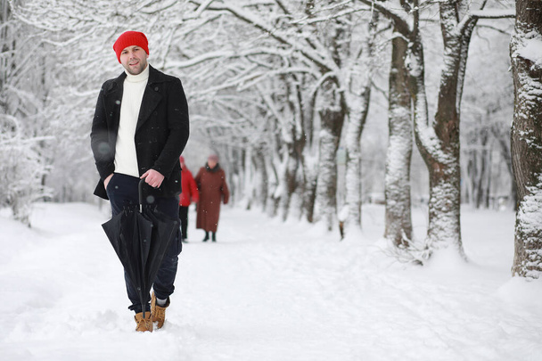 Muž na procházce v parku. Mladý muž s v zimě sněhu - Fotografie, Obrázek