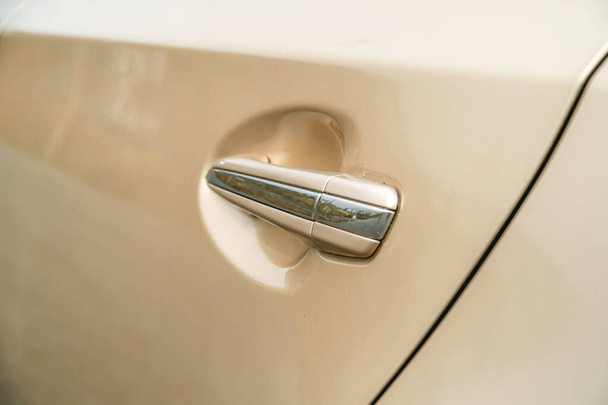 Photo of door chrome handle of car of gold color  - Fotografie, Obrázek