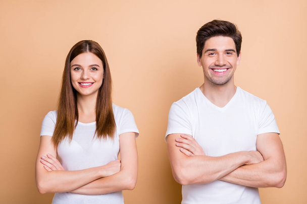 Close-up portrait of his he her she nice attractive lovely cheerful cheery content successful couple wearing white t-shirt folded arms isolated over beige pastel color background - Fotó, kép