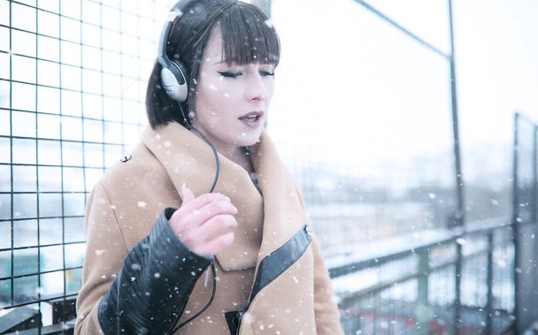 Girl in headphones listening to music outdoors - Photo, Image