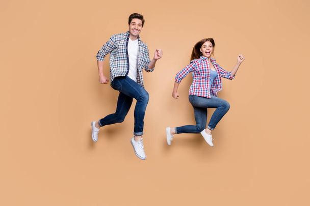 Full body profile photo of two people excited lady guy jumping high rushing discount shopping tourists traveling wear casual clothes isolated beige background - Zdjęcie, obraz