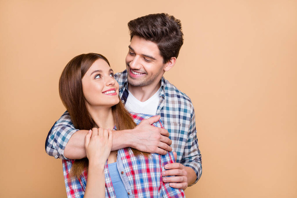 Photo of cheerful positive cute charming gorgeous couple of two people hugging embracing smiling toothily enjoying each other company isolated over beige pastel color background - Fotoğraf, Görsel