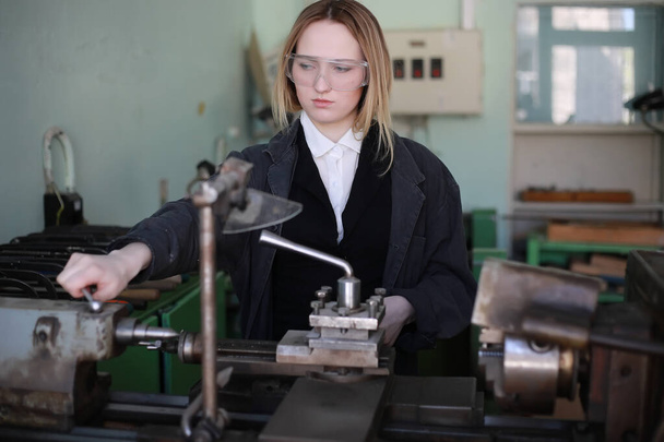 Νεαρή γυναίκα μηχανικός που εργάζεται στο εργαλειομηχανών - Φωτογραφία, εικόνα