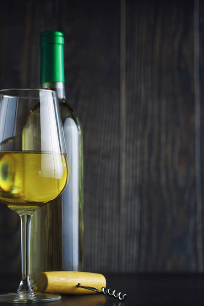 Transparentní láhev bílého suchého vína na stole. Bílé víno gl - Fotografie, Obrázek