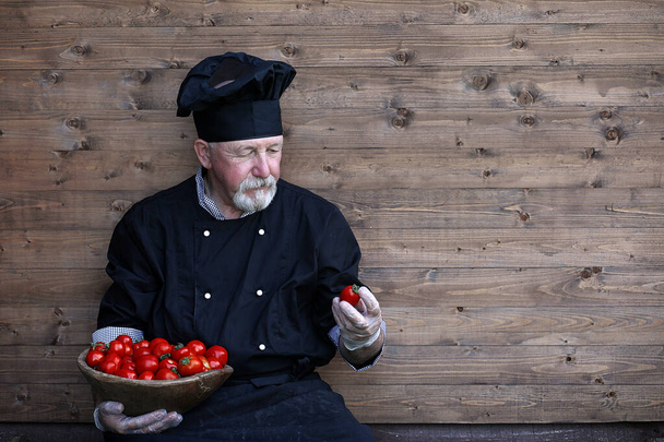 Chef old in uniform with fresh vegetables - Photo, Image