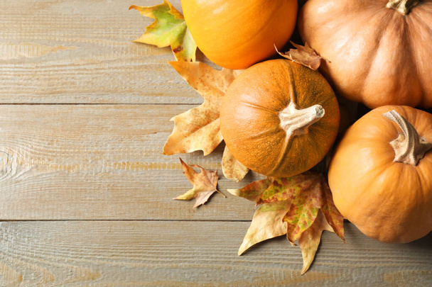 Ripe pumpkins on wooden background, flat lay with space for text. Holiday decoration - 写真・画像