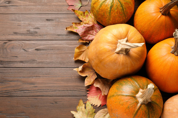 Flat lay composition with different ripe pumpkins on wooden background, space for text. Holiday decoration - Foto, immagini