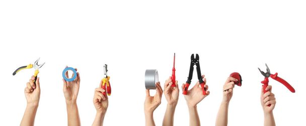 Mãos femininas com ferramentas de eletricista em fundo branco
 - Foto, Imagem