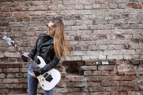  ギターでレザー ジャケットのロック ミュージシャンの女の子  - 写真・画像