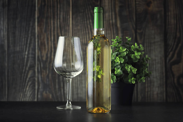 Διαφανές μπουκάλι λευκό ξηρό κρασί στο τραπέζι. Λευκό κρασί gl - Φωτογραφία, εικόνα