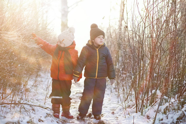 słodkie dzieci w ciepłe ubrania gry w parku zimowym  - Zdjęcie, obraz