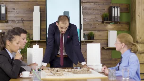 Arquitecto en traje de negocios inclinado hacia adelante la mesa
 - Metraje, vídeo