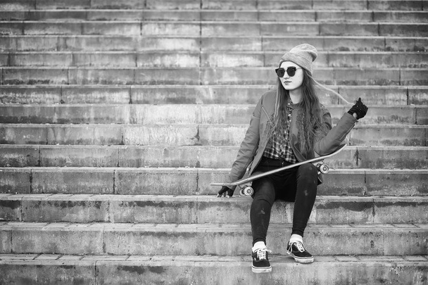 Een meisje van jonge hipster is een skateboard rijden. Meisjes vriendinnen f - Foto, afbeelding