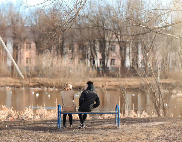 Genç bir çift parkta bir araya geldi. Sevgili oturuyor bir  - Fotoğraf, Görsel