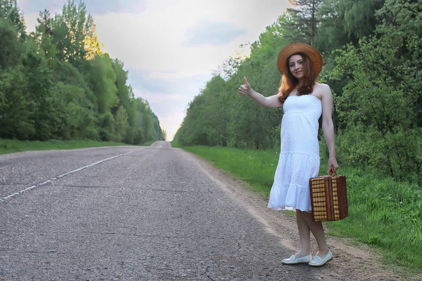 chica en un vestido blanco y maleta de mimbre caminando sobre rieles
 - Foto, Imagen