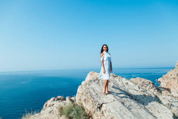 portrait d'une belle femme aux cheveux longs sur une montagne donnant sur la mer
 - Photo, image