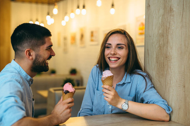 happy couple eating ice cream in candy shop - Фото, зображення