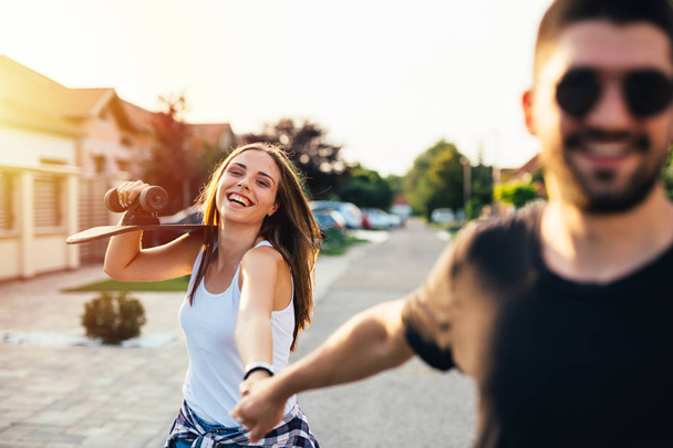 beautiful happy young couple driving skateboard outdoor - Foto, Imagem