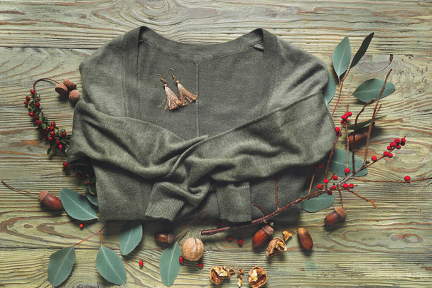 Hermosa composición otoñal con suéter cálido sobre fondo de madera
 - Foto, Imagen