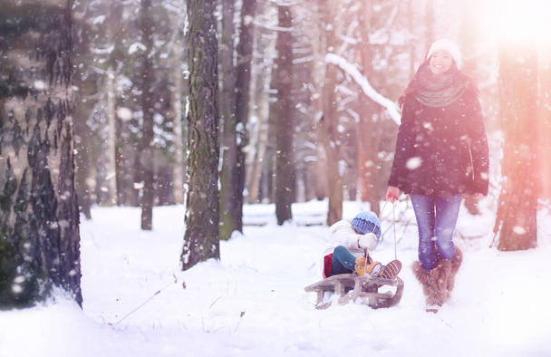 Een sprookje van de winter, een jonge moeder en haar dochter rit een slee - Foto, afbeelding