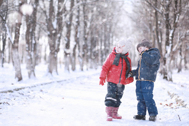 Los niños caminan en el parque primera nieve
 - Foto, Imagen