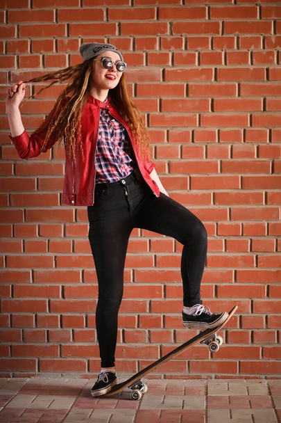 Een meisje van jonge hipster is een skateboard rijden. Meisjes vriendinnen f - Foto, afbeelding