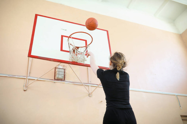 Girl in the gym playing a basketball - Foto, immagini
