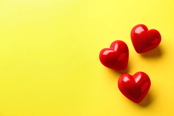 Red hearts on yellow background, flat lay. Space for text - Fotó, kép