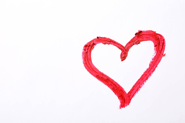 Heart drawn with red lipstick on white paper, top view - Valokuva, kuva