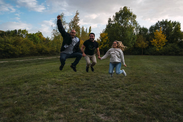 Amigos saltando en el parque como si fuera una victoria - Photo, image