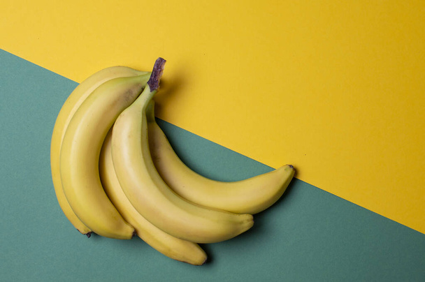黄色と緑色のバナナを背景に熟して熟していない果実の概念は - 写真・画像