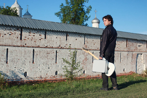Człowiek z gitara elektryczna w przemysłowy krajobraz na zewnątrz - Zdjęcie, obraz