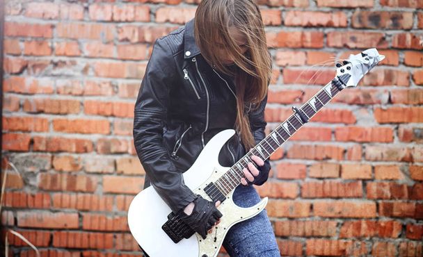 Beautiful young girl rocker with electric guitar. A rock musicia - Photo, Image
